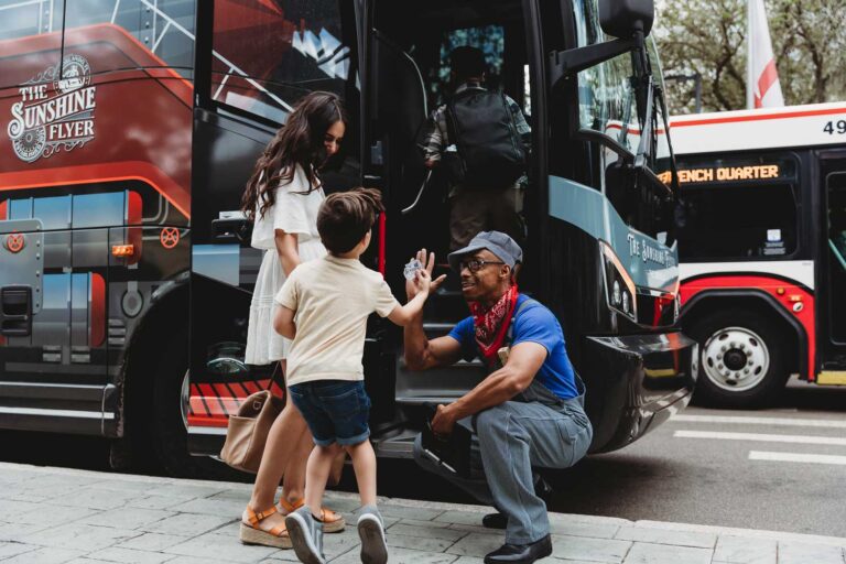conductor-greeting-child-and-mother-entering-bus