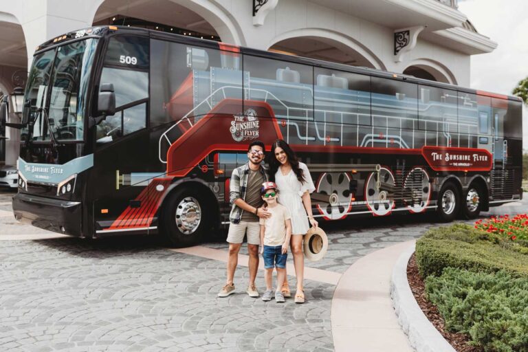 family-posing-for-photo-in-front-of-bus